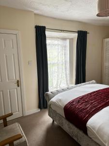 1 dormitorio con cama y ventana en Mulgrave Lodge, en Dun Laoghaire