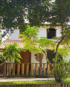 a house with a wooden fence in front of it at Pousada Dendê Caraiva in Caraíva