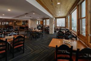 un comedor con mesas, sillas y ventanas en The Lodge at Breckenridge en Breckenridge