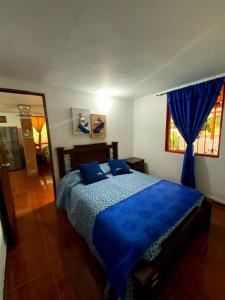 ein Schlafzimmer mit einem blauen Bett mit blauen Kissen in der Unterkunft Casa de campo Jardín in Jardin