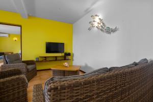 a living room with two couches and a tv at Vert Ocean in Le Marin