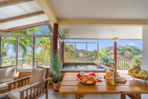 a dining room with a table with food on it at Vert Ocean in Le Marin