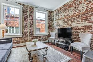 - un salon avec un mur en briques dans l'établissement Loft steps from River Street and City Market, à Savannah