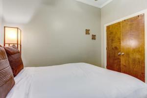 - une chambre avec un lit blanc et une porte en bois dans l'établissement Loft steps from River Street and City Market, à Savannah