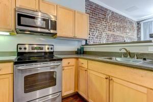 a kitchen with a stove and a microwave at E Bay St Loft by City Market and River Street in Savannah