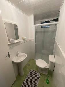 a bathroom with a shower and a toilet and a sink at Casa Cerejeiras in Campos do Jordão