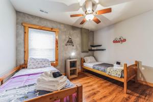 - une chambre avec 2 lits et un ventilateur de plafond dans l'établissement Mountain Serenity- Rustic Cabin Getaway home, à Clyde