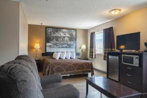 a hotel room with a bed and a tv at Super 8 by Wyndham Grants in Grants