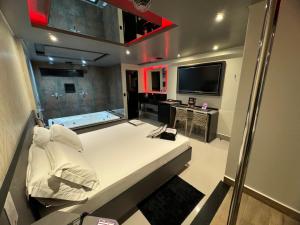 Prestige Motel 3 في ساو باولو: غرفة نوم بسرير كبير وتلفزيون بشاشة مسطحة