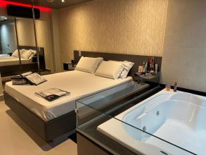 Prestige Motel 3 في ساو باولو: غرفة نوم مع سرير وحوض استحمام