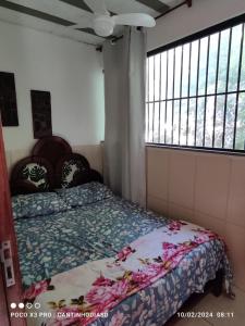 um quarto com uma cama com uma colcha em Cantinho Dias Dutra em Angra dos Reis