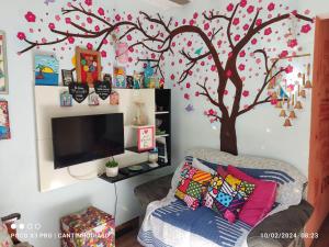 a living room with a tree mural on the wall at Cantinho Dias Dutra in Angra dos Reis