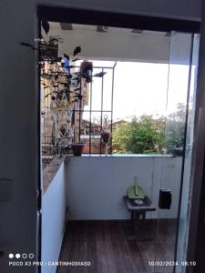 una puerta abierta a un balcón con mesa en Cantinho Dias Dutra, en Angra dos Reis