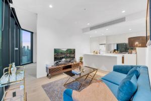 a living room with a blue couch and a table at Melbourne Square Apartments in Melbourne