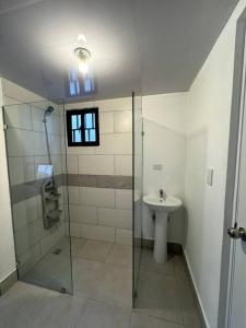 y baño con ducha y lavamanos. en Cozy 2 Bedroom Apartment., en Santo Domingo