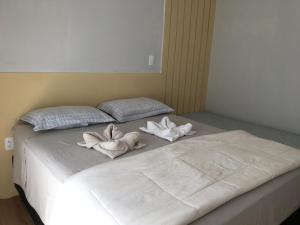 a bed with two towels on top of it at Aconchego das flores in Campos do Jordão