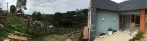 a blue house with a view of a mountain at Aconchego das flores in Campos do Jordão