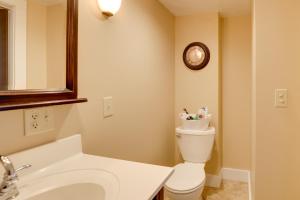 a bathroom with a toilet and a clock on the wall at Finger Lakes Retreat 3 Mi to Seneca and Keuka Lake in Himrod +22 photos