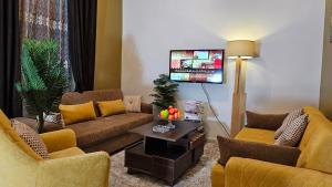 salon z 2 kanapami i telewizorem w obiekcie Peaceful in Heart of El mansoura w mieście Al-Mansura