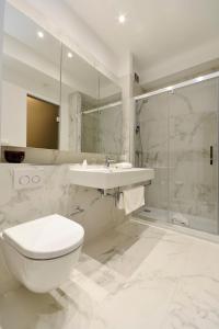 La salle de bains est pourvue de toilettes, d'un lavabo et d'une douche. dans l'établissement Apartments with a swimming pool Podstrana, Split - 20098, à Podstrana