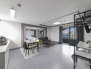 a kitchen and living room with a table and chairs at Sokcho Sinabro in Sokcho