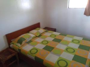 1 dormitorio con 1 cama con un edredón colorido en Casa Máncora Guesthouse, en Máncora