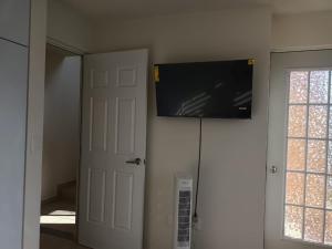 TV de pantalla plana colgada en una pared junto a una puerta en Casa en Cuernavaca, 
