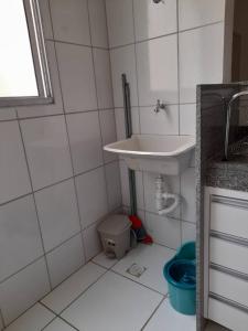 een witte badkamer met een wastafel en een vuilnisbak bij Apartamento Completo - Res Pq Humanita - Bl 02 in Uberlândia