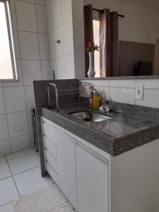 een badkamer met een wastafel en een spiegel bij Apartamento Completo - Res Pq Humanita - Bl 02 in Uberlândia