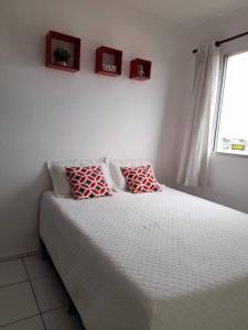 een slaapkamer met een bed met 2 kussens erop bij Apartamento Completo - Res Pq Humanita - Bl 02 in Uberlândia
