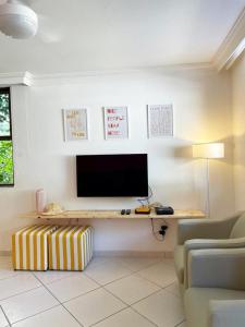 Casa Aurora في سلفادور: غرفة معيشة مع مكتب مع تلفزيون وأريكة