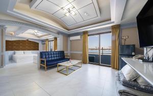 a living room with a blue couch and a table at Sokcho Sinabro in Sokcho