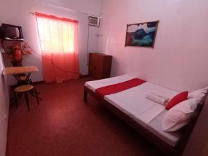 une petite chambre avec un lit et une fenêtre dans l'établissement William Hearts Pension, à Puerto Princesa