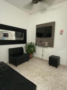 uma sala de estar com um sofá e uma televisão de ecrã plano em Apartamento central primer piso em Apartadó