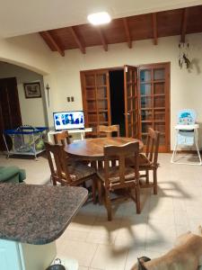 Un comedor con mesa y sillas y un televisor. en Un ambiente cómodo y placentero, en Guaymallén 12 fotos más