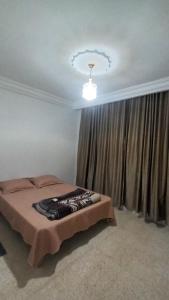 1 dormitorio con 1 cama frente a una ventana en Appartement Hanna en Nassene Srhira