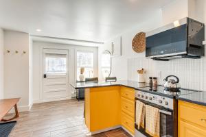 a kitchen with yellow cabinets and a stove at Pet-Friendly Denver Home 2 Blocks to City Park! in Denver