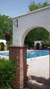 a brick archway next to a swimming pool at Villa Varadero in Skopje
