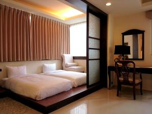 1 dormitorio con cama, silla y espejo en 王牌旅館 Ace Hotel, en Hualien City