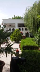 una casa blanca con muchas plantas y árboles en Villa Varadero, en Skopje