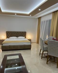 a bedroom with a bed and a table and chairs at City Heart Apartments in Ulcinj