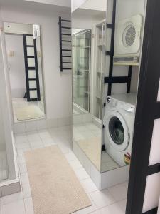 a laundry room with a washing machine and a mirror at Condor Surfers - Hosted by Coastal Letting Company in Gold Coast