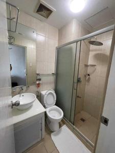 a bathroom with a toilet and a sink and a shower at Robinson manila birchtower in Manila