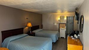 um quarto de hotel com duas camas e uma televisão em Hopwood Motel em Uniontown