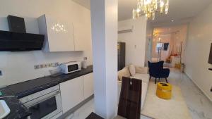 a kitchen with white cabinets and a living room at The Vittins in Tantra Hill