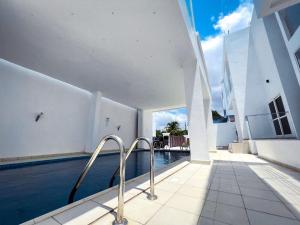 a swimming pool next to a building with a house at The Vittins in Tantra Hill