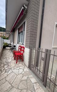 duas cadeiras vermelhas sentadas ao lado de uma casa em Casa Bardolina - Baia Flaminia em Pesaro