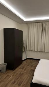 1 dormitorio con cama, armario y cortina en غرفه وصاله بدخول ذاااتي, en Riad