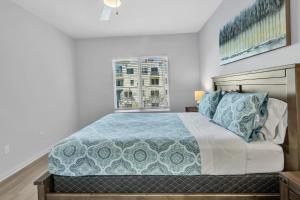 a bedroom with a bed with a blue comforter and a window at Spacious two bedroom one bath In Little Italy in San Diego