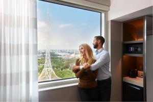 Un uomo e una donna in piedi davanti a una finestra di Holiday Inn Express Melbourne Southbank, an IHG Hotel a Melbourne
